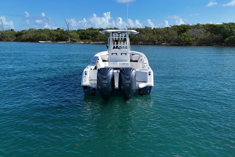 Slide: The Image of 2023 Tidewater 292 CC Adventure boat with dual engines on calm water. - 6