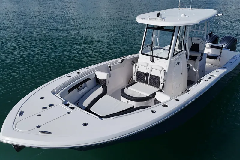 Slide: The Image of 2023 Tidewater 292 CC Adventure boat on calm water, showcasing sleek design and spacious deck. - 7