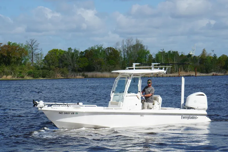 The Image of 2015 Everglades 243 Center Console boat cruising on a scenic lake. - 1