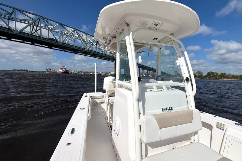 Slide: The Image of 2015 Everglades 243 Center Console boat cruising under a bridge on a sunny day. - 11