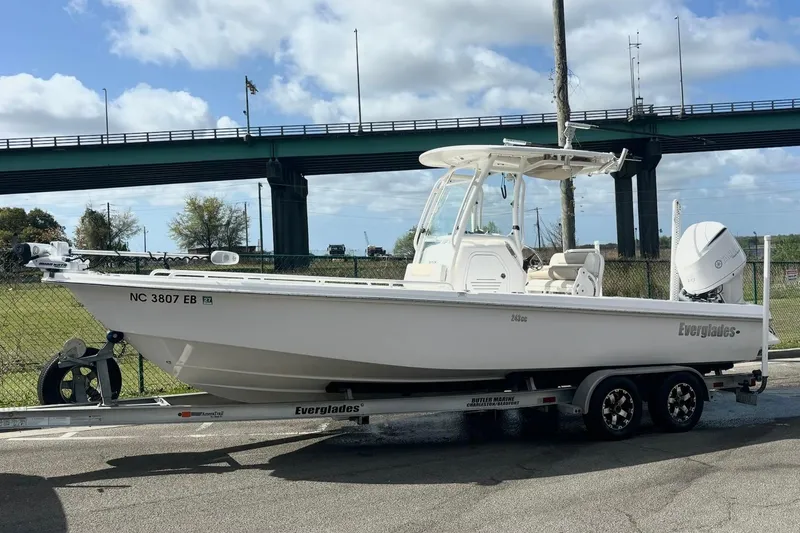 Slide: The Image of 2015 Everglades 243 Center Console boat on trailer, parked near a bridge. - 13