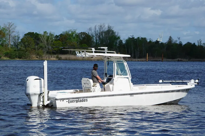 Slide: The Image of 2015 Everglades 243 Center Console boat on calm water, surrounded by trees. - 3