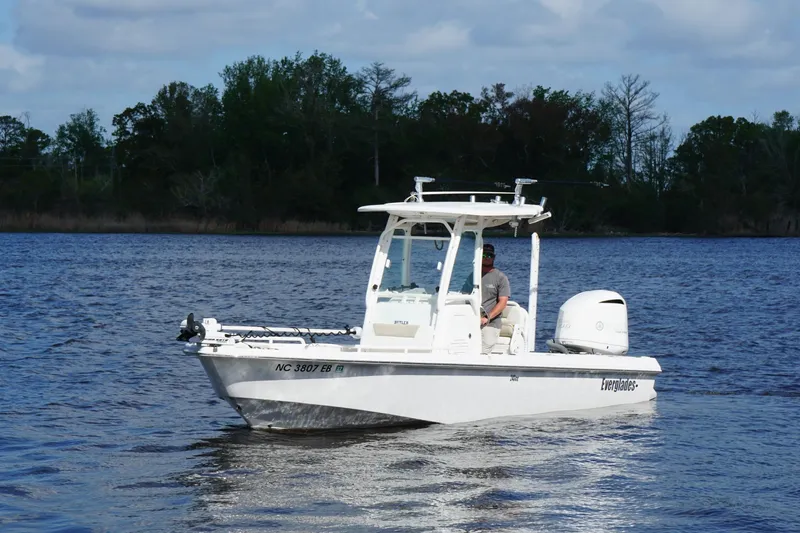 Slide: The Image of 2015 Everglades 243 Center Console boat cruising on a serene lake. - 4