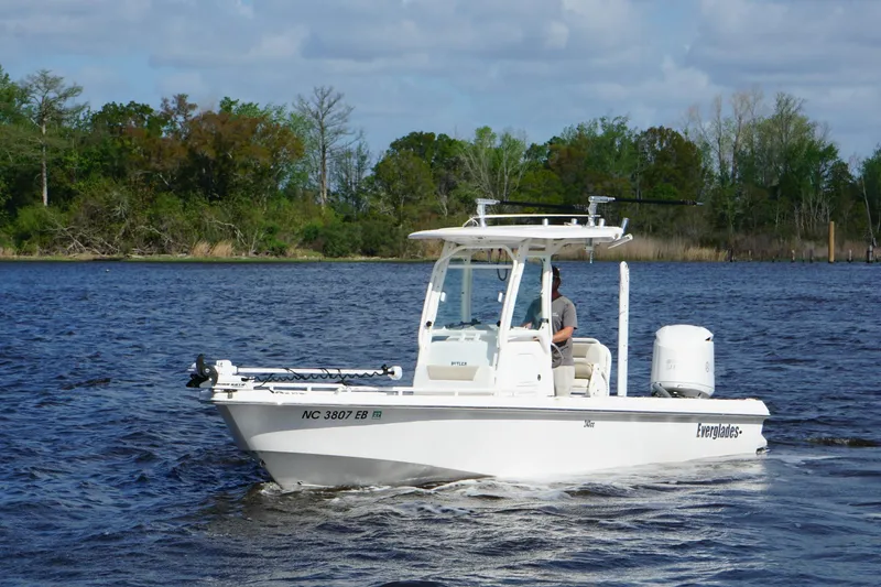 Slide: The Image of 2015 Everglades 243 Center Console boat cruising on a scenic lake. - 6