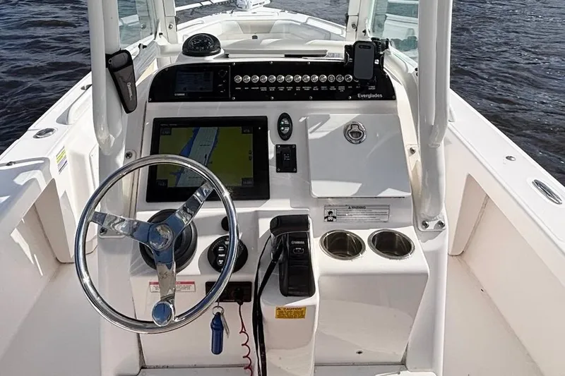Slide: The Image of 2015 Everglades 243 Center Console boat dashboard with steering wheel and navigation system. - 7