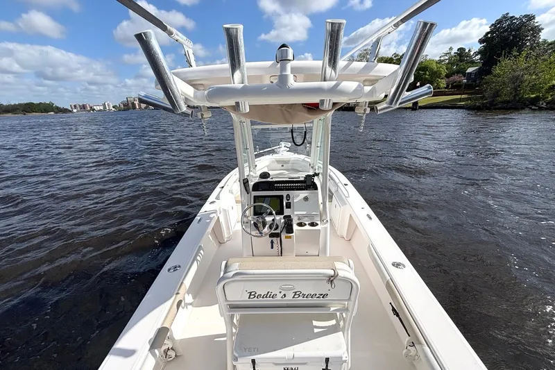 Slide: The Image of 2015 Everglades 243 Center Console boat on water, featuring fishing rod holders and steering console. - 8