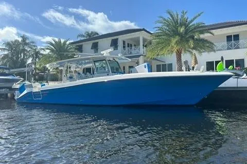 The Image of 2016 Hydra-Sports 4200 Siesta boat docked by waterfront homes, under a clear blue sky. - 0