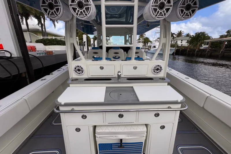 Slide: The Image of 2016 Hydra-Sports 4200 Siesta boat interior with speakers and seating, docked by a waterfront. - 15
