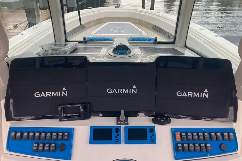 Slide: The Image of 2016 Hydra-Sports 4200 Siesta boat dashboard with Garmin navigation displays and control panels. - 2