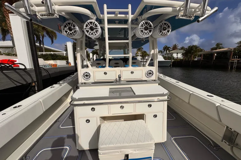 Slide: The Image of 2016 Hydra-Sports 4200 Siesta boat interior with speakers and seating, docked by the water. - 34