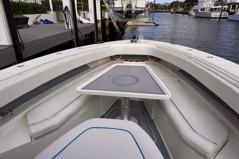 Slide: The Image of 2016 Hydra-Sports 4200 Siesta boat interior with seating and table, docked by the water. - 9