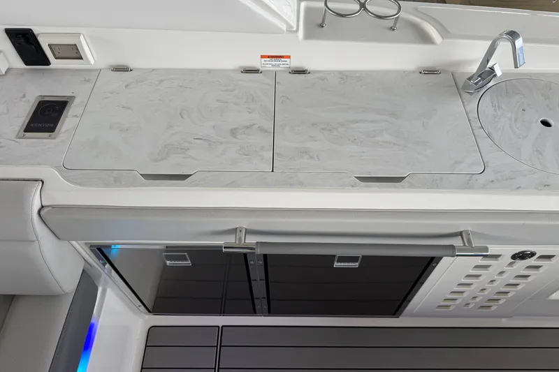 Slide: The Image of 2025 Sea Ray SLX 400 boat kitchen with marble countertop, sink, and modern appliances. - 10