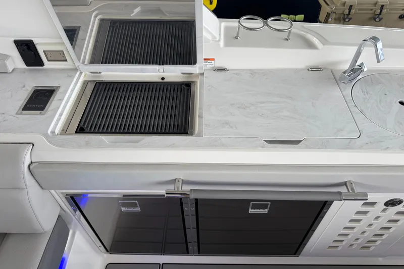 Slide: The Image of 2025 Sea Ray SLX 400 boat kitchen with grill, sink, and storage. - 11