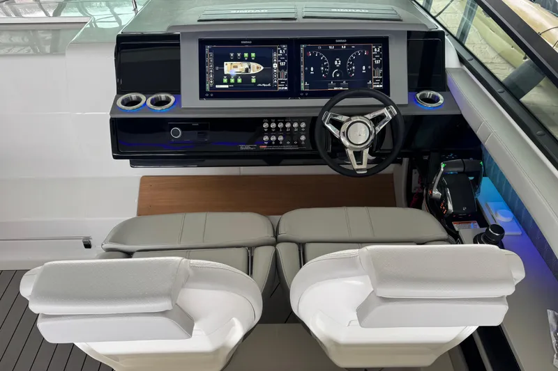 Slide: The Image of 2025 Sea Ray SLX 400 helm with dual screens and modern steering wheel. - 14