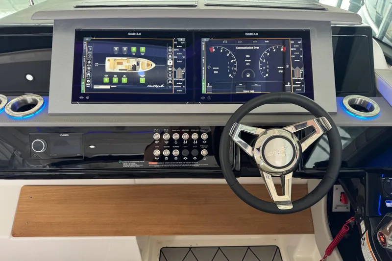 Slide: The Image of 2025 Sea Ray SLX 400 helm with dual Simrad displays and modern steering wheel. - 17