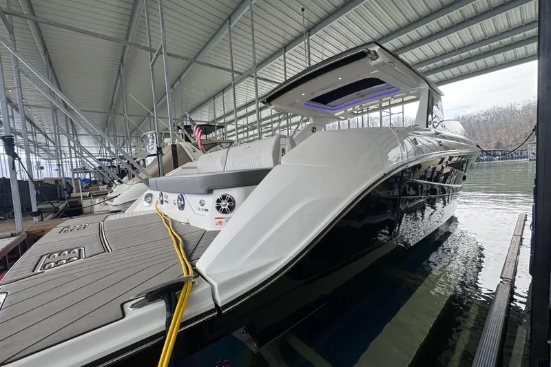 Slide: The Image of 2025 Sea Ray SLX 400 luxury boat docked in a covered marina. - 2
