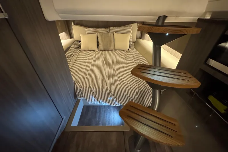 Slide: The Image of Luxurious cabin interior of 2025 Sea Ray SLX 400 yacht with striped bedding. - 24