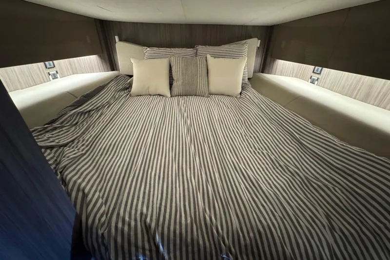 Slide: The Image of Luxurious cabin interior of 2025 Sea Ray SLX 400 with striped bedding and cushions. - 26