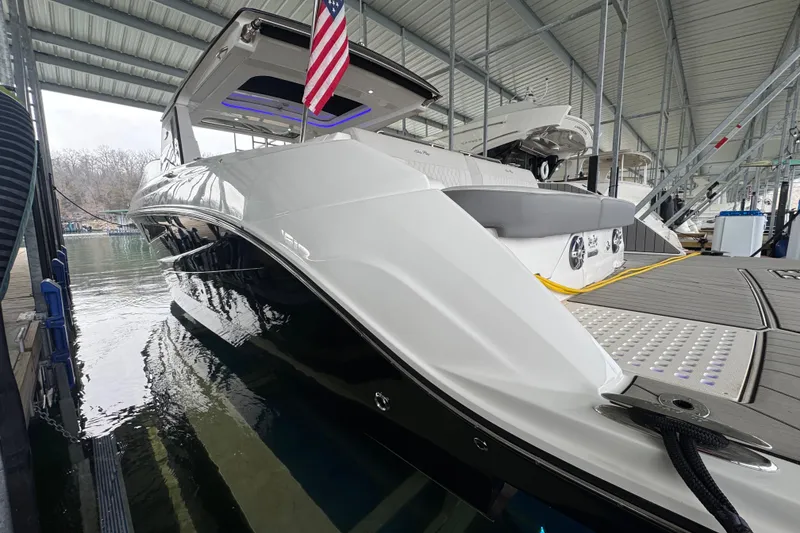 Slide: The Image of 2025 Sea Ray SLX 400 luxury boat docked under a covered marina. - 30