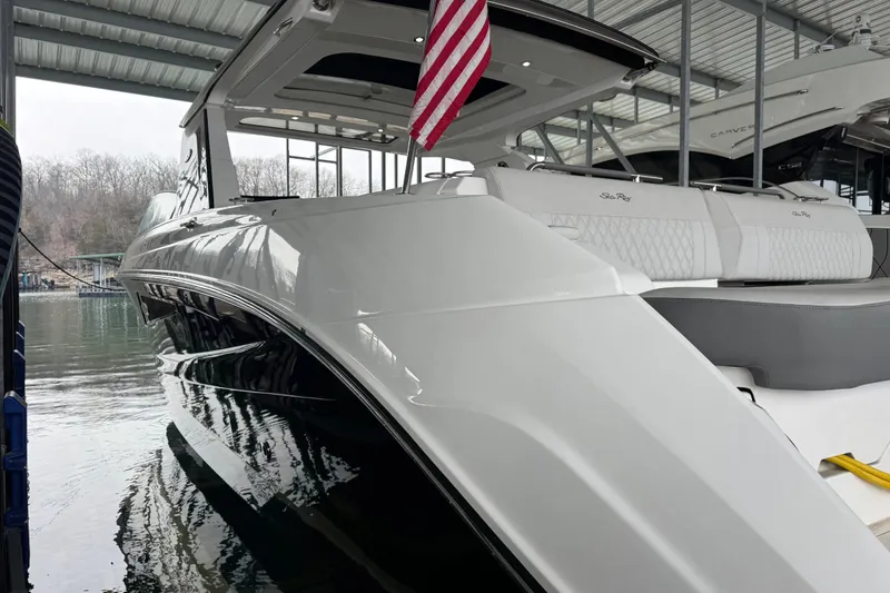 Slide: The Image of 2025 Sea Ray SLX 400 yacht docked under a covered marina with American flag. - 4