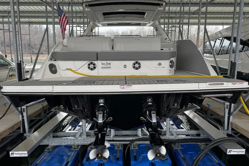 Slide: The Image of 2025 Sea Ray SLX 400 boat docked, rear view with American flag and dual propellers. - 6