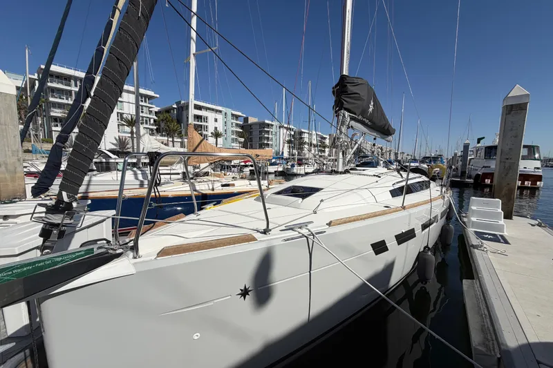 Slide: The Image of 2024 Jeanneau Sun Odyssey 349 sailboat docked at a marina under clear blue skies. - 12