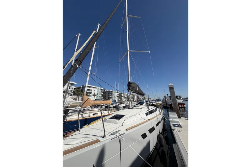 Slide: The Image of 2024 Jeanneau Sun Odyssey 349 sailboat docked at marina under clear blue sky. - 13