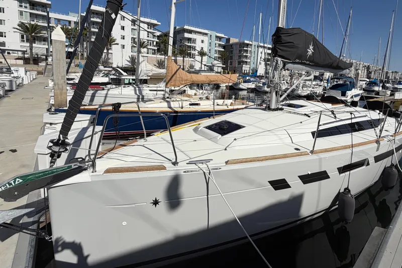 Slide: The Image of 2024 Jeanneau Sun Odyssey 349 sailboat docked in a marina, surrounded by other boats. - 15