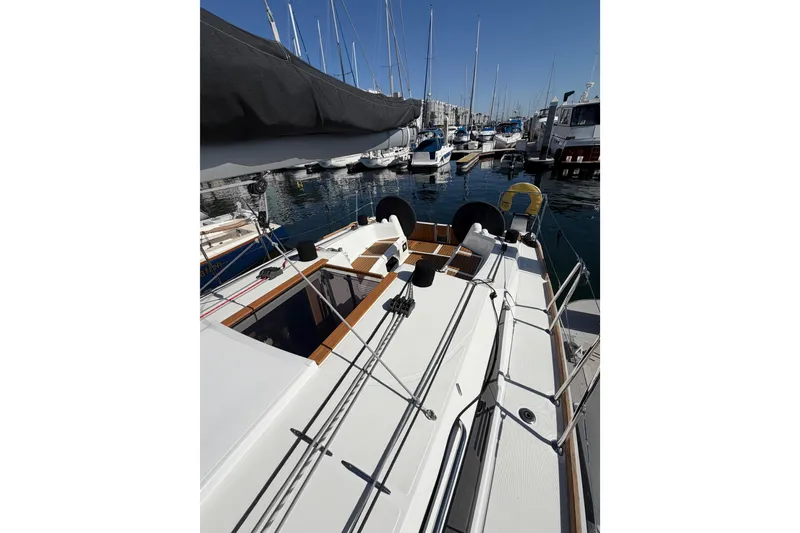 Slide: The Image of 2024 Jeanneau Sun Odyssey 349 sailboat docked in a marina, showcasing sleek deck design. - 17