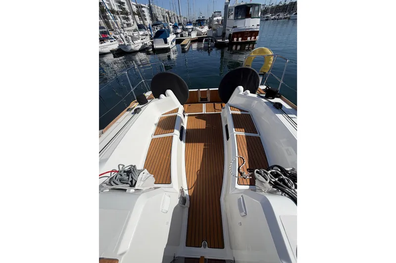 Slide: The Image of 2024 Jeanneau Sun Odyssey 349 sailboat deck with teak flooring in marina setting. - 20