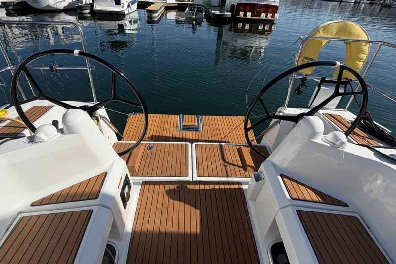 Slide: The Image of 2024 Jeanneau Sun Odyssey 349 sailboat cockpit with dual steering wheels and teak decking. - 27