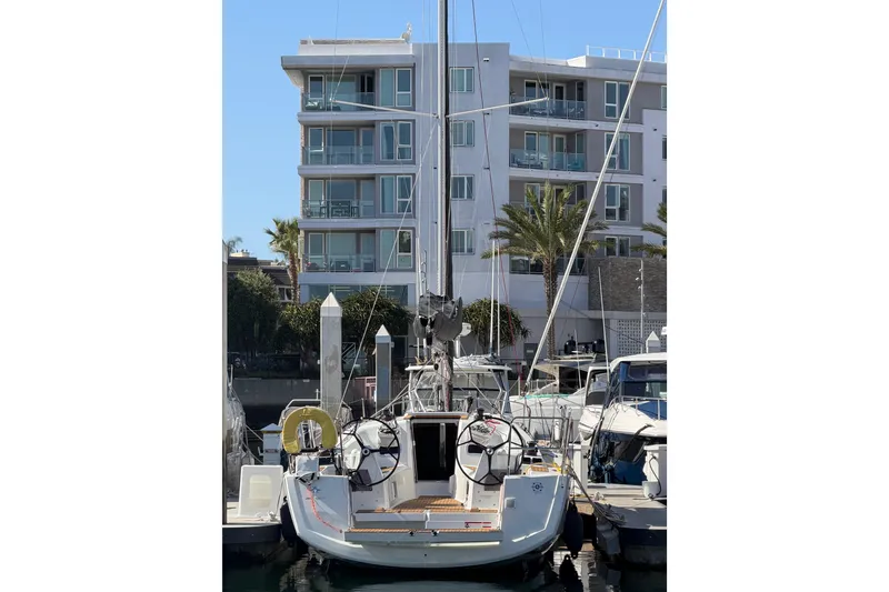 Slide: The Image of 2024 Jeanneau Sun Odyssey 349 sailboat docked in marina, modern building in background. - 33
