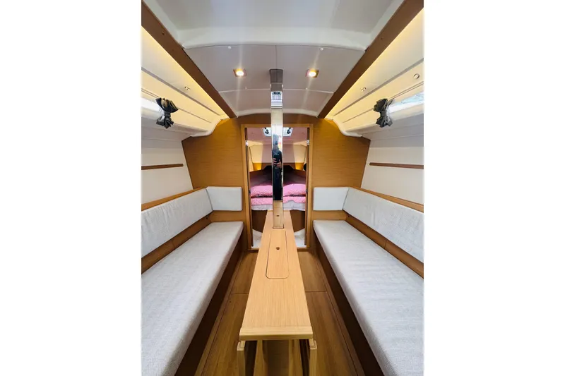 Slide: The Image of Interior of 2024 Jeanneau Sun Odyssey 349 sailboat, featuring cozy seating and wooden finishes. - 40