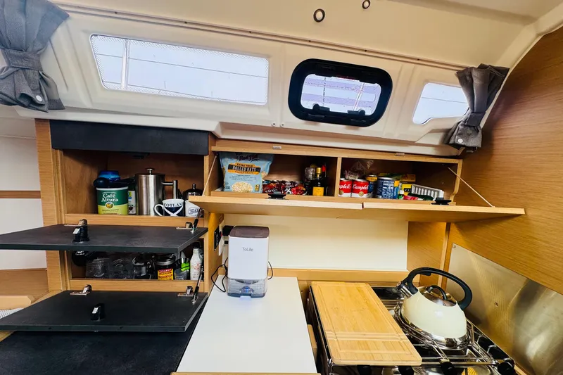 Slide: The Image of 2024 Jeanneau Sun Odyssey 349 yacht kitchen with shelves, stove, and storage. - 47