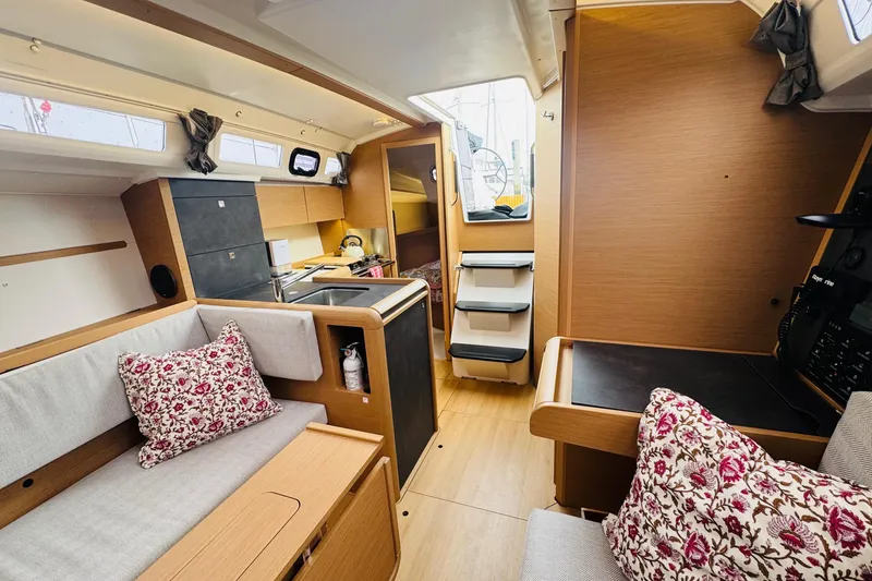 Slide: The Image of 2024 Jeanneau Sun Odyssey 349 interior with modern kitchen, cozy seating, and floral cushions. - 49