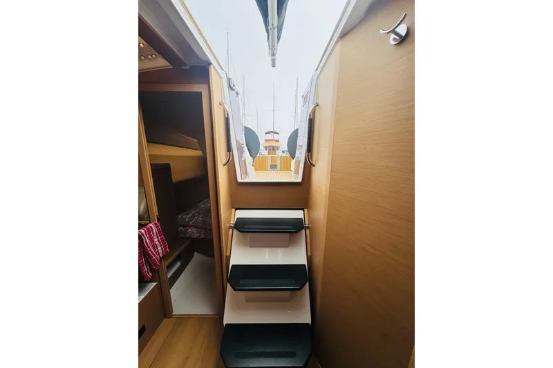 Slide: The Image of Interior view of 2024 Jeanneau Sun Odyssey 349 sailboat with wooden stairs and cabin. - 56