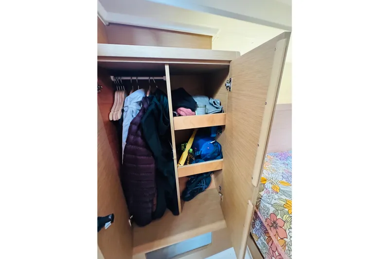 Slide: The Image of 2024 Jeanneau Sun Odyssey 349 cabin closet with clothes and storage shelves. - 61