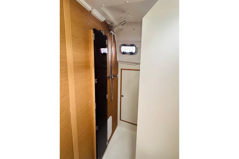 Slide: The Image of 2024 Jeanneau Sun Odyssey 349 interior with wooden cabinetry and compact design. - 70