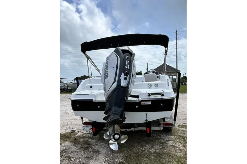 Slide: The Image of 2018 Hurricane SunDeck Sport 232 OB boat with Evinrude outboard motor, parked on trailer. - 10