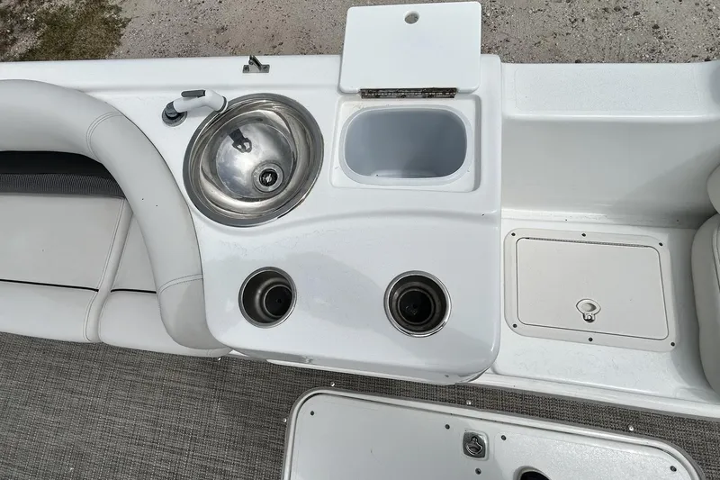 Slide: The Image of 2018 Hurricane SunDeck Sport 232 OB boat interior with sink and storage compartments. - 24