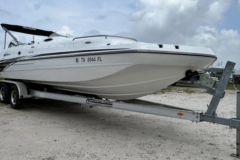 Slide: The Image of 2018 Hurricane SunDeck Sport 232 OB boat on trailer, parked outdoors under cloudy sky. - 3