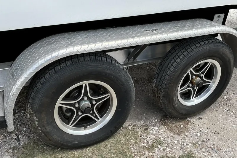 Slide: The Image of Trailer wheels for 2018 Hurricane SunDeck Sport 232 OB boat on gravel surface. - 31