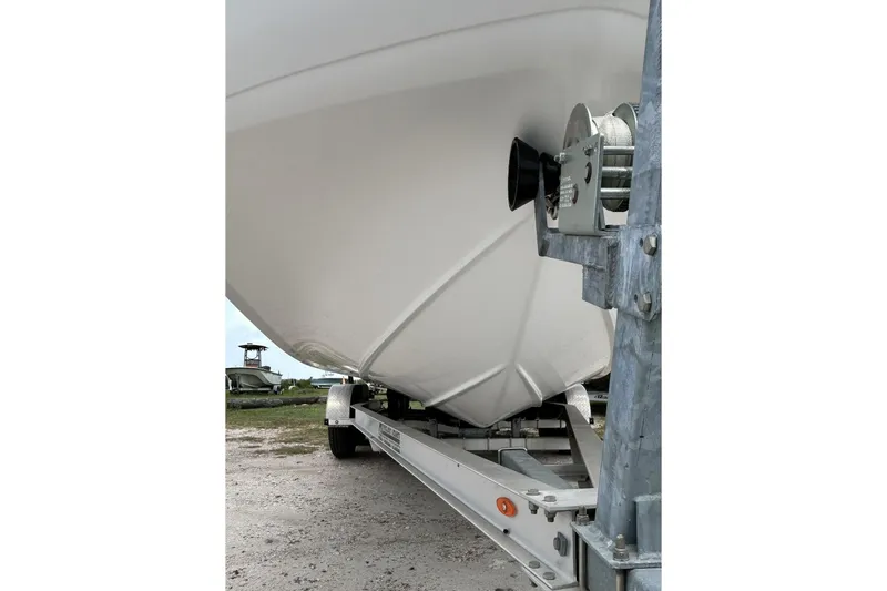 Slide: The Image of 2018 Hurricane SunDeck Sport 232 OB boat on trailer, close-up view of hull and winch. - 5
