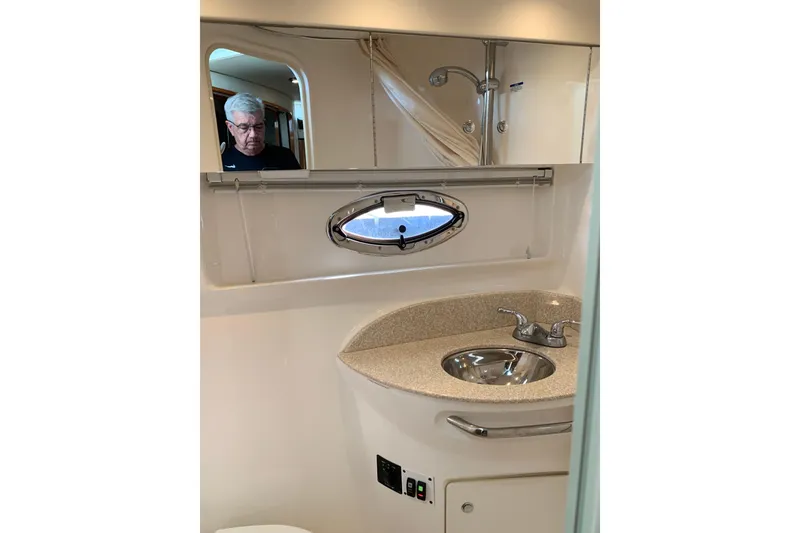 Slide: The Image of 2007 Chaparral 350 Signature yacht bathroom with sink, mirror, and porthole window. - 15