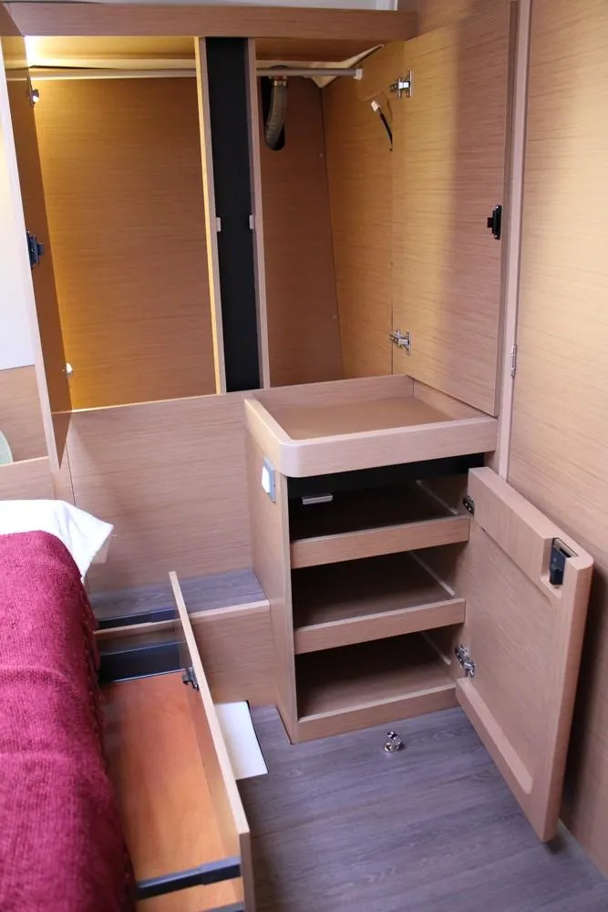 Slide: The Image of Interior of 2025 Jeanneau Sun Odyssey 440 yacht with wooden cabinetry and storage. - 13