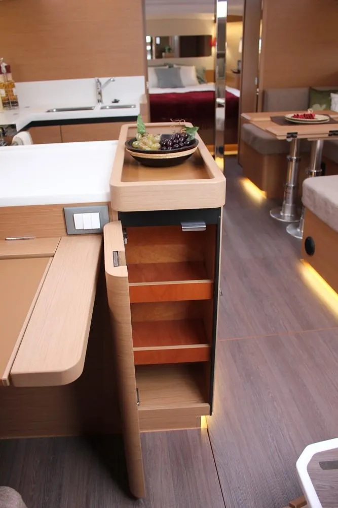 Slide: The Image of Interior of 2025 Jeanneau Sun Odyssey 440 yacht, featuring modern kitchen and storage. - 23