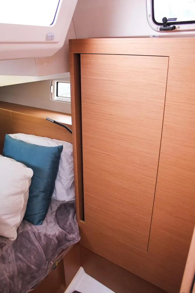 Slide: The Image of Interior cabin of 2025 Jeanneau Sun Odyssey 440 yacht, featuring cozy bedding and wooden paneling. - 31