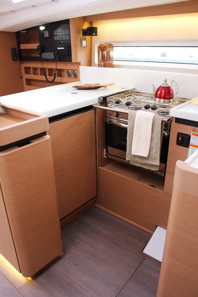 Slide: The Image of Modern kitchen interior of 2025 Jeanneau Sun Odyssey 440 yacht, featuring sleek wood cabinetry and appliances. - 45
