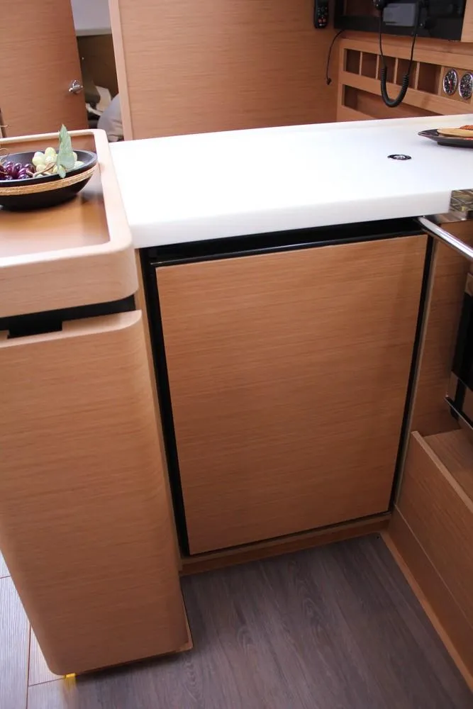 Slide: The Image of 2025 Jeanneau Sun Odyssey 440 yacht interior, featuring a modern wooden kitchen area. - 17
