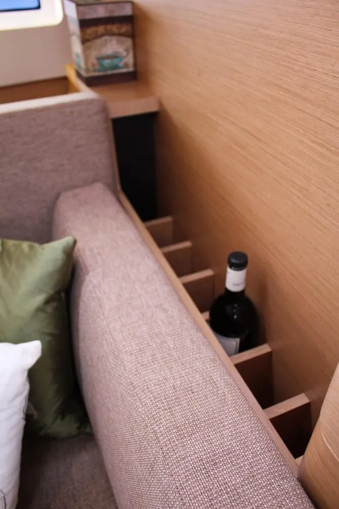 Slide: The Image of Interior of 2025 Jeanneau Sun Odyssey 440 with wine storage behind sofa. - 20